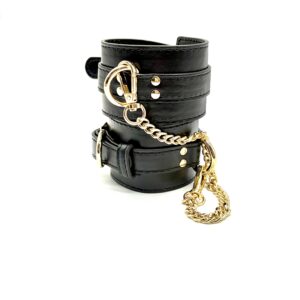 RUMAEL black leather look cuffs with gold chain connection